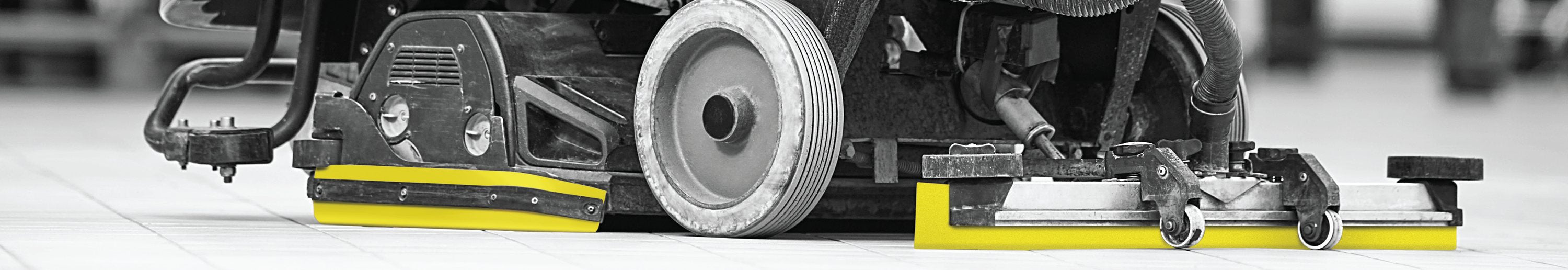 Floor scrubber with yellow squeegee blades.